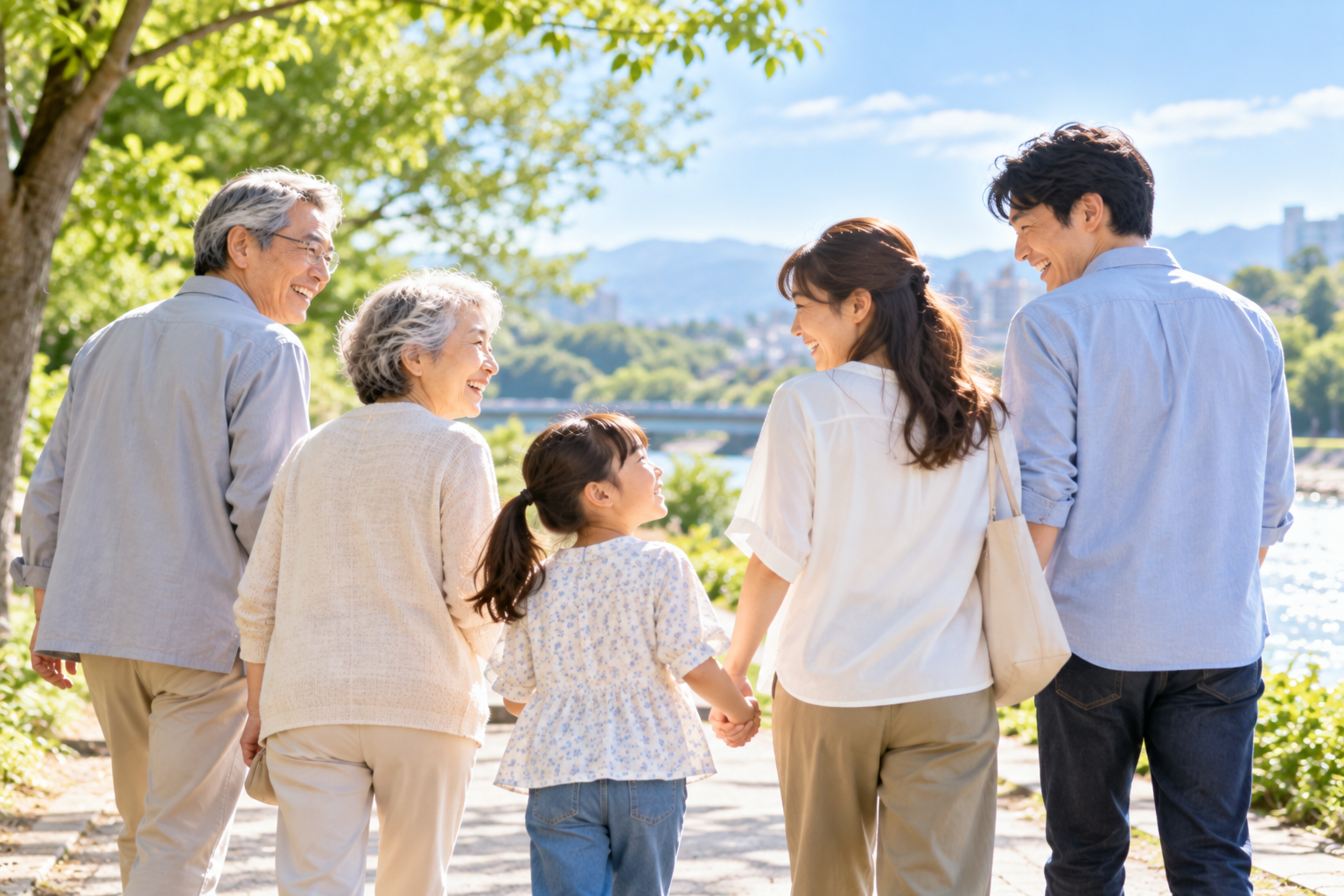 緑豊かな水辺を家族で歩きながら会話を楽しむ様子